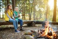 Cute young sisters roasting hotdogs on sticks at bonfire. Children having fun at camp fire. Camping with kids in fall forest Royalty Free Stock Photo