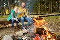 Cute young sisters roasting hotdogs on sticks at bonfire. Children having fun at camp fire. Camping with kids in fall forest Royalty Free Stock Photo