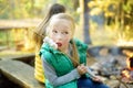 Cute young sisters roasting marshmallows on stick at bonfire. Children having fun at camp fire. Camping with children in fall Royalty Free Stock Photo