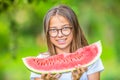 Cute young teen grirl holding in hands watermelon in garden