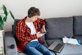 Cute young teenager with smartphone in his hands on the couch at home. Royalty Free Stock Photo