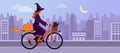 Cute witch riding a bicycle in the city street