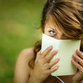 Cute young woman covering her face with a book Royalty Free Stock Photo