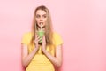 Cute young woman drinking a green smoothie and thinking about healthy nutrition detox food.