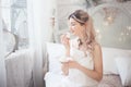 Cute young woman eating sweets in the morning in the bedroom. Gentle winter morning. Royalty Free Stock Photo