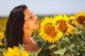 Cute young woman enjoying sunflowers