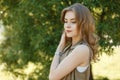 Cute young woman in a fashionable summer vest in a stylish white T-shirt posing outdoors in the park on a background of green Royalty Free Stock Photo