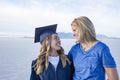 Cute Young woman in her graduation cap and gown celebrating with her mom Royalty Free Stock Photo