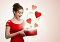 Cute young woman holding a box with red heart flying out Royalty Free Stock Photo