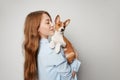 Cute young woman hugging and kissing her puppy basenji dog. Love between dog and owner. Isolated on white background Royalty Free Stock Photo