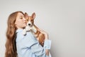 Cute young woman hugging and kissing her puppy basenji dog. Love between dog and owner. Isolated on white background Royalty Free Stock Photo