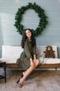 A cute young woman in a joyful mood is ready to celebrate Christmas and New Year, sitting on the couch Royalty Free Stock Photo