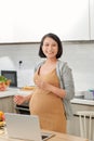 Cute young woman in the kitchen is preparing fruit vegan salad or a healthy smoothie and having fun Royalty Free Stock Photo