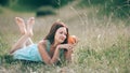 Cute young woman with orange lying on the lawn.
