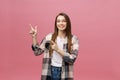 Cute young woman points a finger away isolate over pink background. Copy Space. Royalty Free Stock Photo