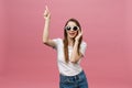 Cute young woman points a finger away isolate over pink background. Copy Space. Royalty Free Stock Photo