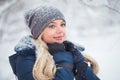 Cute young woman portrait playing with snow in warm woolen hat and coat in winter park Royalty Free Stock Photo