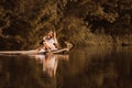 Cute young woman sitting by the lake touching water by her leg Royalty Free Stock Photo