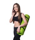 Cute young woman in sportswear with green mat ready for workout. Smiling and talking on the phone. Isolated on white background. Royalty Free Stock Photo