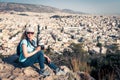 Cute young woman takes a picture of Athens cityscape