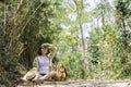 Cute young woman taking a break from forest walk in green tree background with straw fog Royalty Free Stock Photo