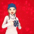 Cute young woman in warm winter clothing holding a Christmas coffee mug Royalty Free Stock Photo