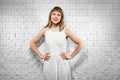 cute young woman in white dress against soundproof wall in the studio