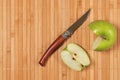 Cuted green apple and knife on bamboo mat