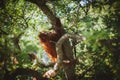 Cutest baby orangutan hangs in a tree in zoo Royalty Free Stock Photo