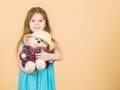 Cutest ever. Kid little girl carefully hug soft toy teddy bear beige background. Tender attachments. Small girl hold