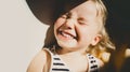 Cutest little girl smiling and squinting in sunlight. Happy toddler having fun. Portrait of playful child preschool age. Lifestyle