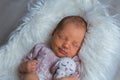 Cutest newborn girl sleeping sweetly on photosession