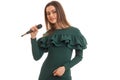 Cutie brunette woman in elegnat green dress with microphone Royalty Free Stock Photo