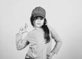 Cutie in cap. Girl cute child wear cap or snapback hat beige background. Little girl wearing bright baseball cap. Modern