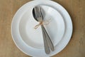 Cutlery decorated with a bowl, on a white plate. Set on a wooden table. Spoon and fork on a plate. Suitable as a background. Eaten Royalty Free Stock Photo