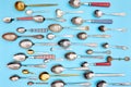 Cutlery. Flat lay photo of variety of antique silverware and gold kitchen spoons arranged against blue studio background