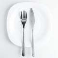 cutlery, fork and knife on an empty white plate on a white backg Royalty Free Stock Photo
