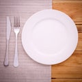 Cutlery red checkered tablecloth tartan on wooden table top view. Royalty Free Stock Photo