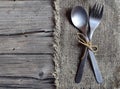 Cutlery set:fork and spoon on burlap cloth on rustic wooden table.Cutlery on old wooden background.Can be used as background menu Royalty Free Stock Photo