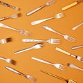 Cutlery. Top view flat lay photo of variety of antique silverware and gold forks arranged against studio background.