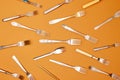 Cutlery. Top view flat lay photo of variety of antique silverware and gold kitchen forks arranged against studio