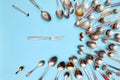 Cutlery. Top view photo one butter-knife surrounded of variety of antique silverware and gold spoons against blue studio