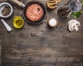 Cutlet of ground beef in a small frying pan, sliced mushrooms, pepper, herbs and salt border ,place text wooden rustic back Royalty Free Stock Photo