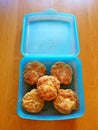 Cutlets wrapped in batter, placed in a blue plastic box