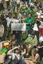 A cutout of George W. Bush saying Mission Accomplished stands in front of a crowd of protesters on a grass lawn at an anti-Iraq Wa