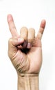 Cut-out shot of a hand holding up Hook `em Horns sign. Fingers with devils horn symbol on white background