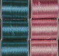 Cutout texture closeup on coils of colored sewing threads blue a