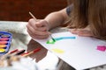 Cutout of an unrecognizable young teenage girl brush painting a chromatic circle on a sheet at sunset with natural light outdoors Royalty Free Stock Photo