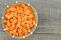 Cuts cubes of carrot in bampoo basket on wooden rustic Royalty Free Stock Photo