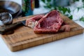 Cuts of raw beef on the cutting board with some green salad in t Royalty Free Stock Photo